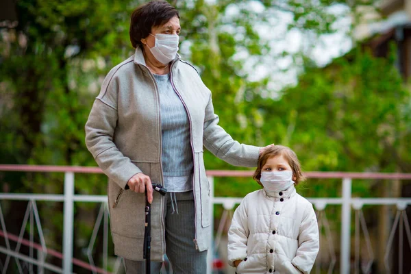 Uma Menina Sua Avó Usando Máscaras Médicas Caminham Uma Rua — Fotografia de Stock