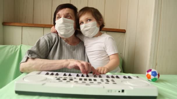 Une femme adulte, avec une petite fille, apprenant à jouer du piano, pendant une quarantaine à domicile, en raison de la pandémie de covide-19 — Video