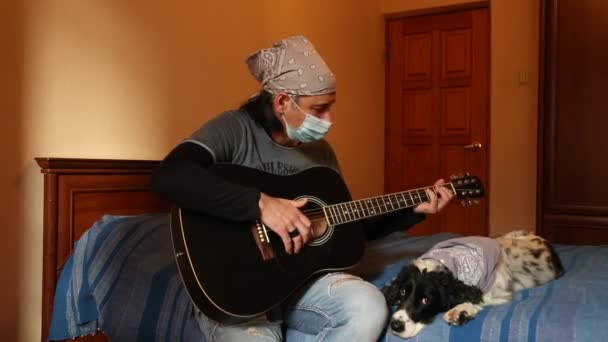 Чоловік Медичній Масці Карантин Вдома Грає Гітарі Рок Стилі Собака — стокове відео