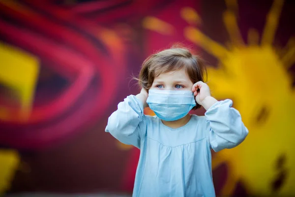 Uma Menina Pequena Bonita Uma Máscara Médica Fica Rua — Fotografia de Stock