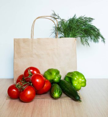 Bir dizi yeni ürün ve açık arkaplanda kahverengi bir kese kağıdı.