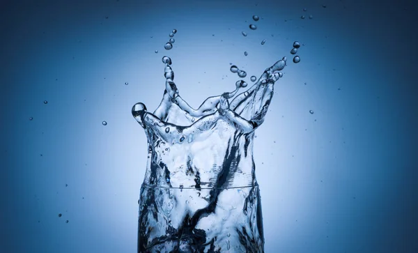 Salpicadura de agua en vidrio con cubitos de hielo —  Fotos de Stock