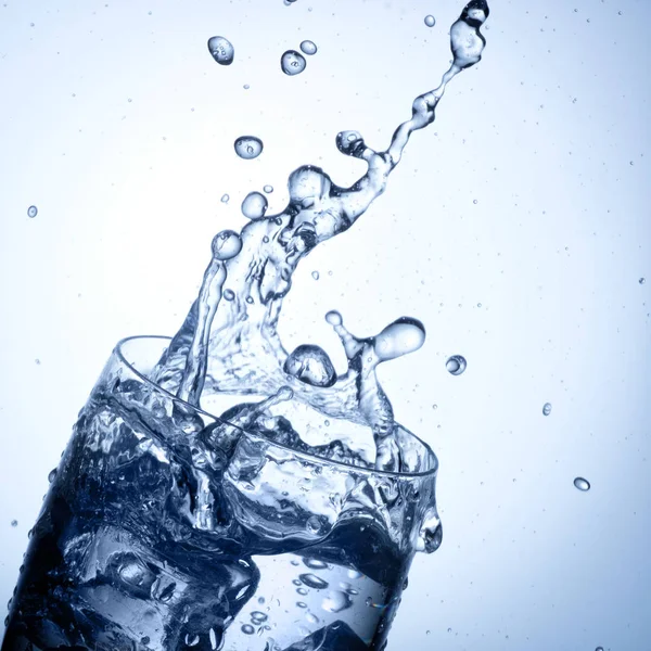 Éclaboussure d'eau en verre avec glaçons — Photo