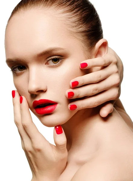 Fiatal nő vörös körmök és vörös ajkak, megható az arcát — Stock Fotó