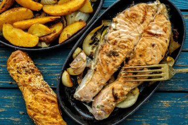 Tavada somon biftek tavada sebzeler, limon, soğan ve