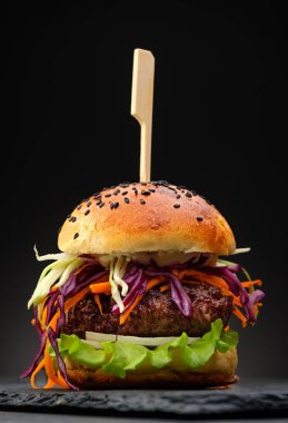 Siyah arka plan üzerinde taze sebze ile ev yapımı hamburger