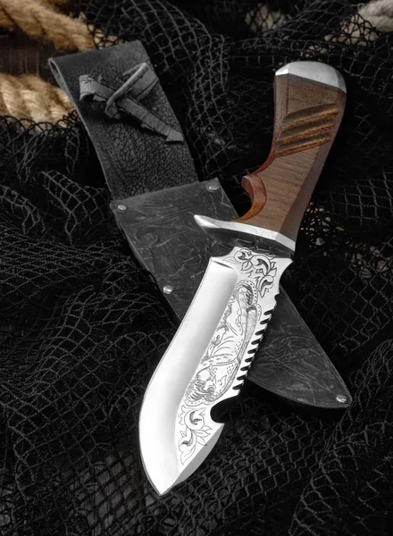 Охотничий нож с рыболовной сетью на деревянном столе . — стоковое фото