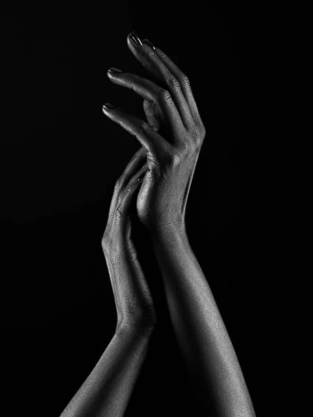 Dark-skinned hands over black background. Beautiful hands. — Stock Photo, Image