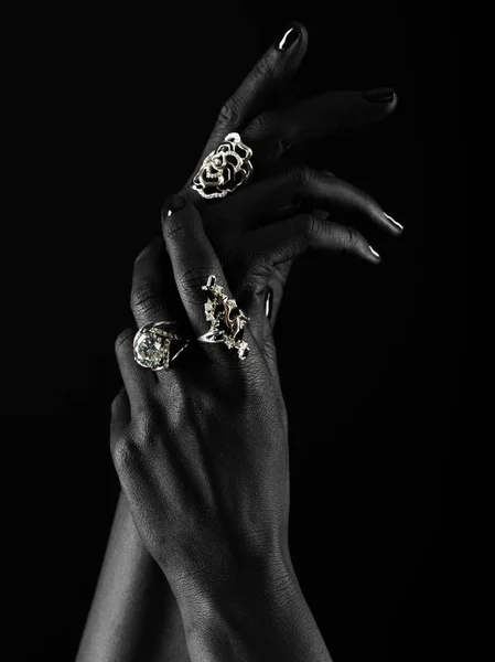 Dark-skinned hand with jewelry on a black background — Stock Photo, Image