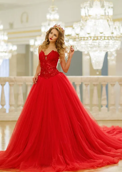 Mulher bonita em um vestido longo vermelho e uma coroa dourada no gr — Fotografia de Stock