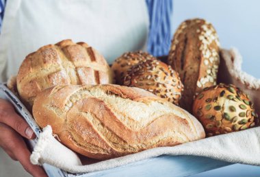 Taze ekmek çeşitleri tutan kadın.