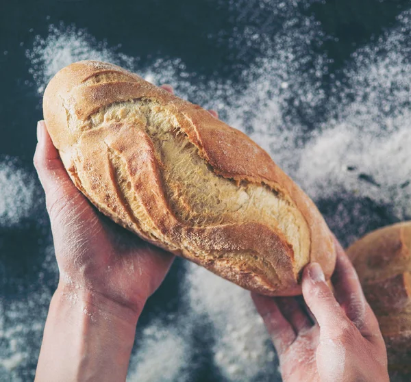 Manos de mujer sosteniendo sabroso pan fresco, vista superior . — Foto de Stock