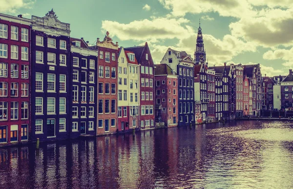 Row of typical houses and boat on Amsterdam canal Damrak with re — Stock Photo, Image