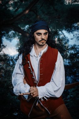 Korsan kostümlü adam portresi açık poz veriyor.