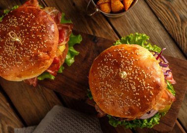 Ahşap masa üzerinde iki lezzetli ev yapımı hamburger. Üstten Görünüm