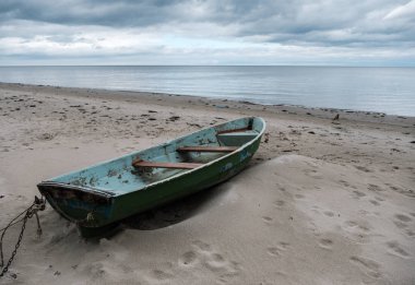 Bulutlu bir gün sahilde eski balıkçı teknesi.