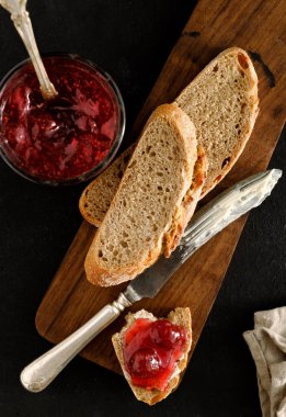 Tereyağı ve reçel ahşap tahta üzerinde ile bulaşmış ekmek parçası