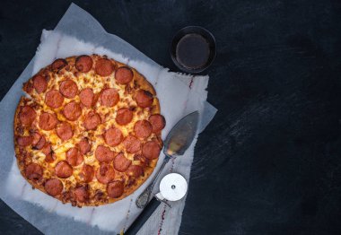 Siyah arka plan üzerine ev yapımı biberli Pizza. Üstten Görünüm.