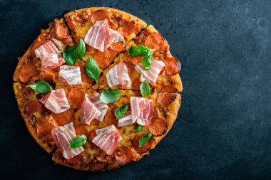 Siyah arka plan üzerinde taze pastırma ile ev yapımı biberli Pizza