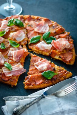 Siyah arka plan üzerinde taze pastırma ile ev yapımı biberli Pizza