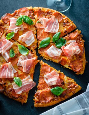 Siyah arka plan üzerinde taze pastırma ile ev yapımı biberli Pizza