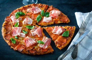 Siyah arka plan üzerinde taze pastırma ile ev yapımı biberli Pizza