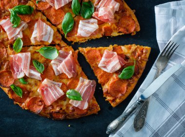 Siyah arka plan üzerinde taze pastırma ile ev yapımı biberli Pizza