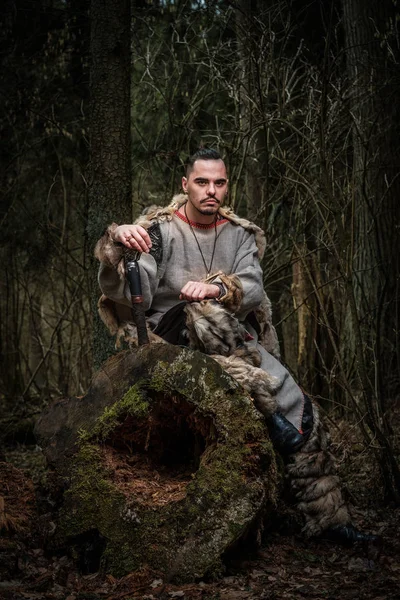 Guerrero vikingo con espada se sienta en el bosque . —  Fotos de Stock