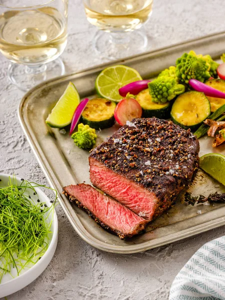 Een gegrilde peper steak gegarneerd met citroen, ui en verse haar — Stockfoto