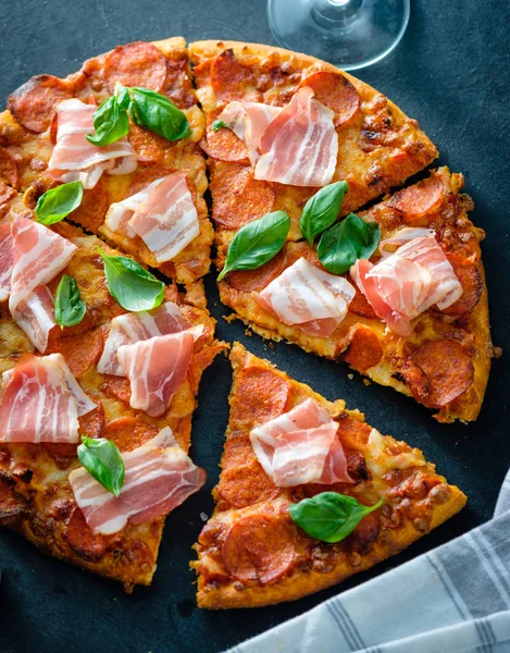 Siyah arka plan üzerinde taze pastırma ile ev yapımı biberli Pizza