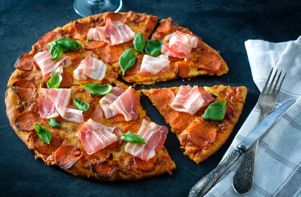 Siyah arka plan üzerinde taze pastırma ile ev yapımı biberli Pizza