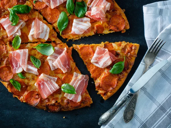 Hausgemachte Pfefferoni-Pizza mit frischem Speck vor schwarzem Hintergrund — Stockfoto