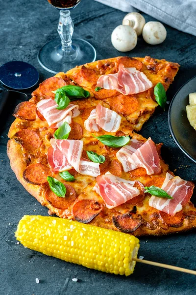 Siyah arka plan üzerinde taze pastırma ile ev yapımı biberli Pizza
