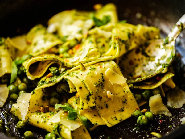 Pappardelle makarna bir close-Up bezelye, pesto, nane ve peynir ile 