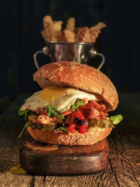 Hamburger met gehakte vlees, ei en rucola op een houten tafel — Stockfoto