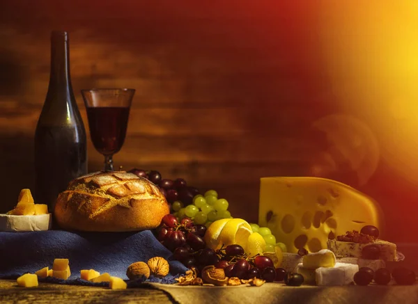Still life with wine, grapes, bread and various sorts of cheese. — Stock Photo, Image