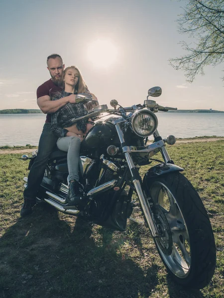 Göl kıyısında gün batımında Motosiklet ile iki sevgili. — Stok fotoğraf