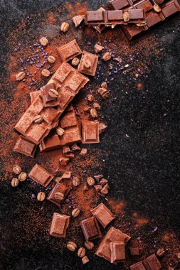 Kırık mermer üzerinde çikolata parçaları ve kakao tozu. 