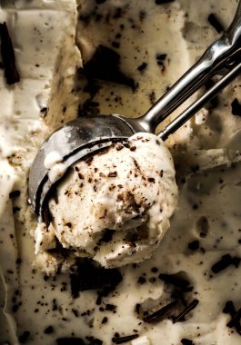 Kremalı dondurma dondurma için bir kaşık çikolata parçaları ile.