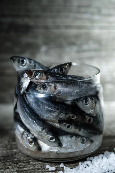 Rå strömming i en glasburk. Processen för saltning fisk. — Stockfoto