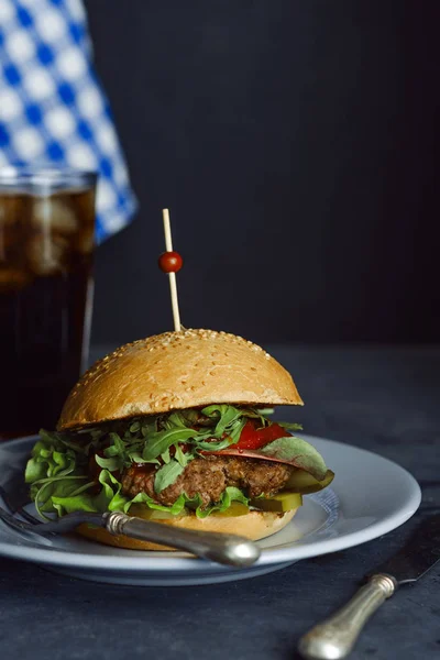 Бургер с говядиной и свежими травами на тёмном столе. Растительная душа — стоковое фото
