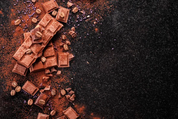 Kırık mermer üzerinde çikolata parçaları ve kakao tozu. 
