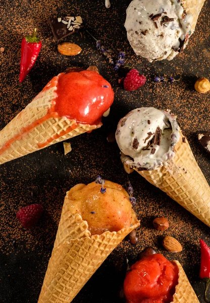 Diferentes variedades de helado en conos de gofre sobre la mesa, t — Foto de Stock