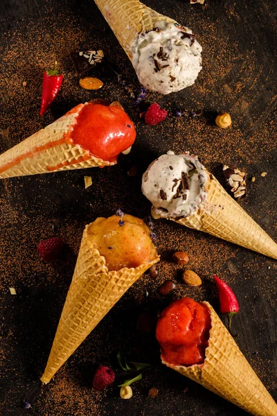 Diferentes variedades de helado en conos de gofre sobre la mesa, t — Foto de Stock