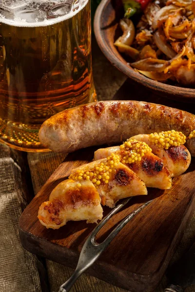 Grilled sausages and stewed cabbage with a mug of beer on a wood — Stock Image Grilled sausages and stewed cabbage with a mug of beer on a wood Stock Picture