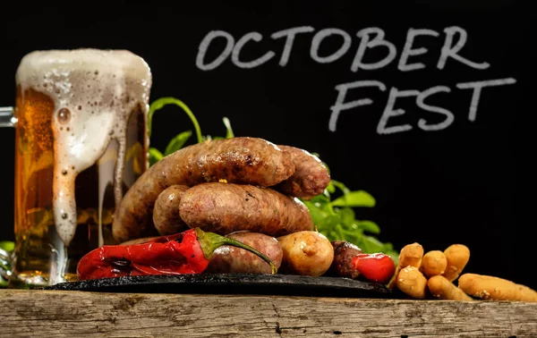 Bir bardak bira ahşap bir masa üzerinde ile ızgara sosis