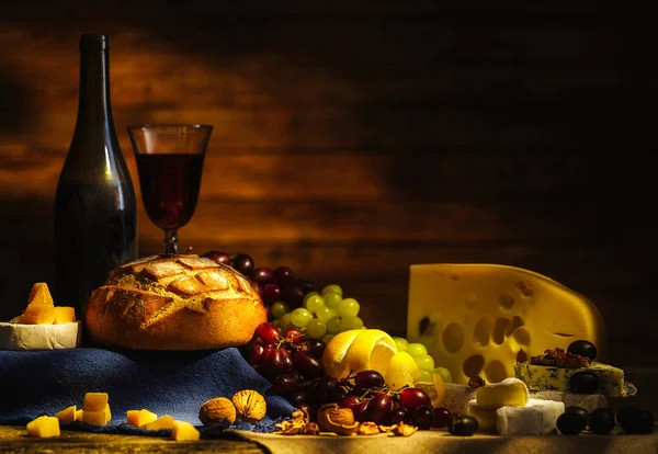 Stilleven met diverse soorten kaas, wijn, druiven en brood. — Stockfoto