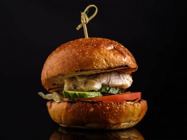 Karanlık bir arka plan üzerinde sebze taze balık burger.