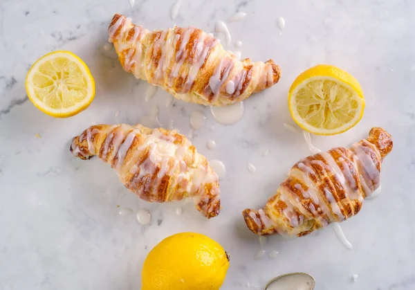 Fresh homemade croissants with lemon icing. — Stock Photo, Image