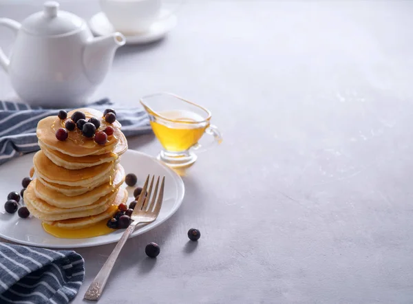 Pancakes with berries and honey on a light background — Stock Photo, Image